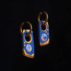 Pair of blue and gold earrings on a black background